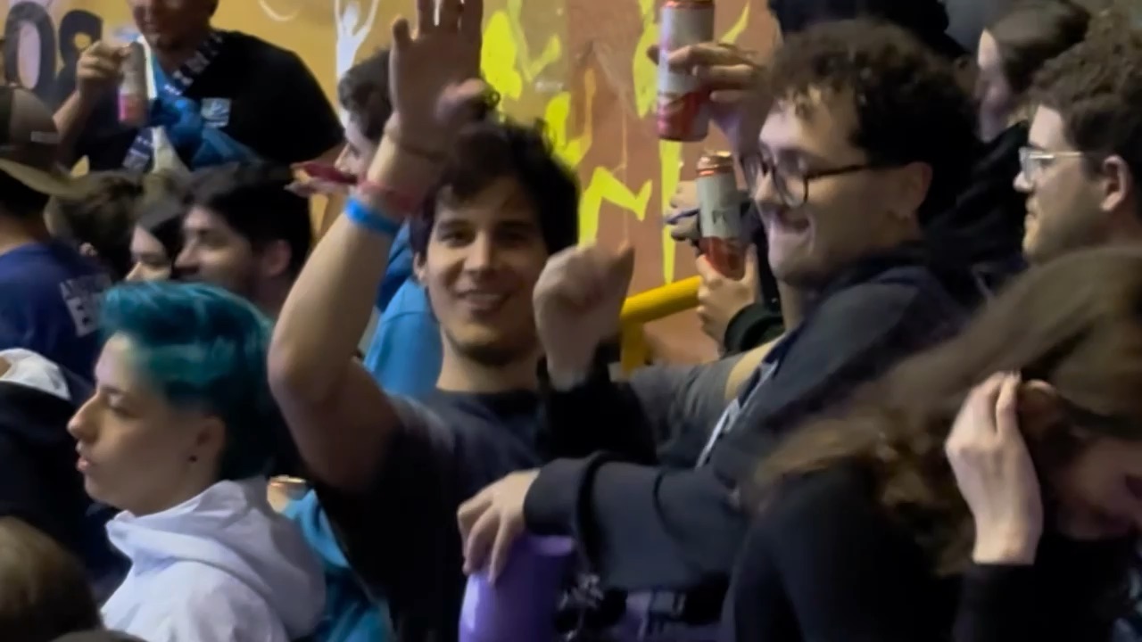 Amigos comemorando na arquibancada dos jogos da faculdade
